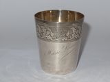 une coupe en argent posée sur une table, sur laquelle figurent des inscriptions