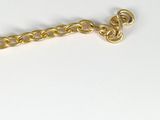 a gold chain with a heart on it on a white surface