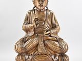 a wooden statue of a buddha sitting on a lotus flower