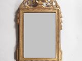 une image représentant un miroir à cadre doré accroché à un mur blanc