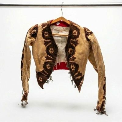 a brown jacket hanging on a clothes rack with a white background