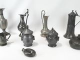 de nombreux vases en métal de toutes sortes sur la table