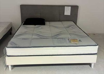 un lit sur lequel est posé un matelas dans une pièce