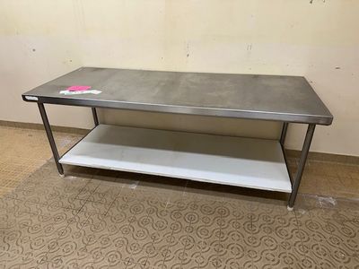 une table en métal avec une étagère posée dessus, dans une pièce