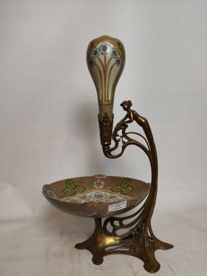 un vase décoratif posé sur un socle, surmonté d'un bol