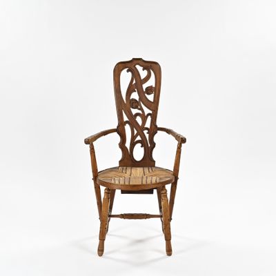 une vieille chaise en bois dont le dossier et l'assise sont sculptés