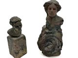 une statue représentant une femme assise à côté d'un buste de femme