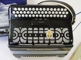 a black accordion sitting on top of a table next to a book