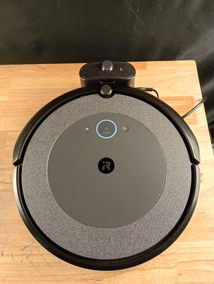 une photo d'un aspirateur robot posé sur une table en bois