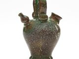 a green vase that is sitting on a white surface