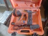 une boîte à outils contenant un marteau et une cloueuse