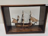 a wooden model of a ship in a glass case