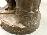 a bronze statue of a man with a hat and boots
