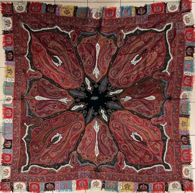 une photo d'un tapis rouge, noir et blanc orné d'un motif floral