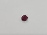 a single red ruby stone sitting on top of a white surface