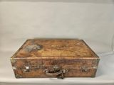 an old wooden suitcase sitting on a white surface