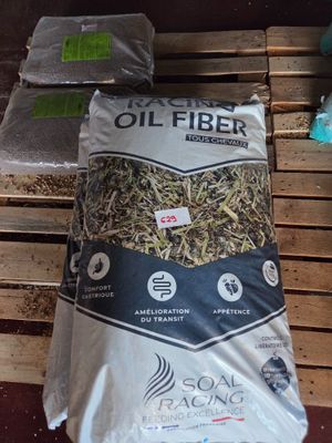 a bag of oil fiber sitting on a pallet next to a pile of wood