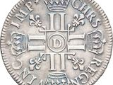 a close up of a silver coin with a cross on it