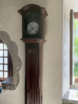 a grandfather clock on the wall next to a window