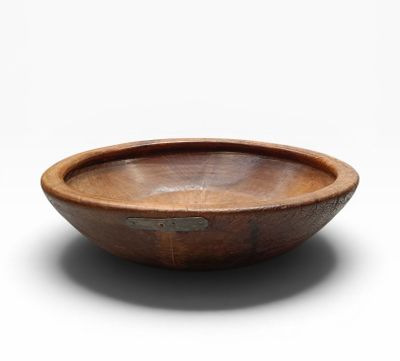 an old wooden bowl sitting on top of a white surface