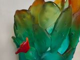 a glass vase that has a red bird on it