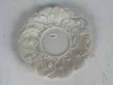 a white plate with a flower on it on a table