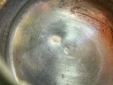 a close up of a metal bowl with a hole in it