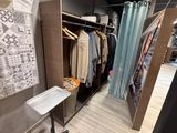 an image of a closet with clothes on hangers and a table
