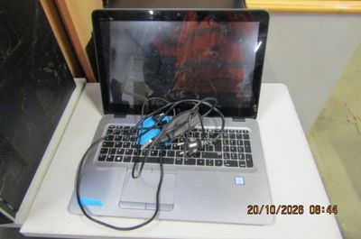 un ordinateur portable posé sur une table blanche