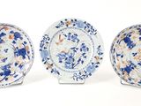 three blue and white plates with floral designs on them on a white surface