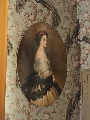 un tableau représentant une femme en robe et un oiseau accroché au mur