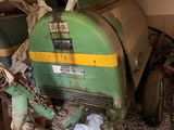 un tracteur qui est garé dans un garage, équipé d'un godet