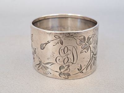 a close up of a silver ring with flowers on it
