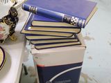 une pile de livres posée sur une table, à côté d'un bol