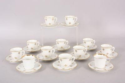 six tasses et soucoupes ornées d'étoiles dorées sont posées sur une table
