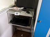 a computer desk with a monitor on it in the corner of a room