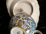 a cup and saucer sitting next to a plate