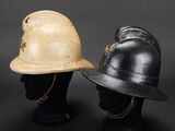 pair of helmets on mannequin heads on a black background