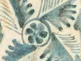 a blue and white tile with a bird on it