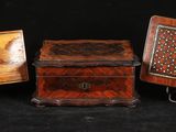 trois petites boîtes en bois ornées de motifs sur fond noir