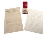 deux feuilles de papier et une bague sont posées sur une table