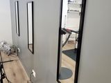 three mirrors on the wall in the hallway of a hair salon