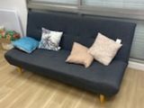 a black couch with pillows on it in a living room