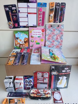 une boîte remplie de fournitures scolaires posée par terre