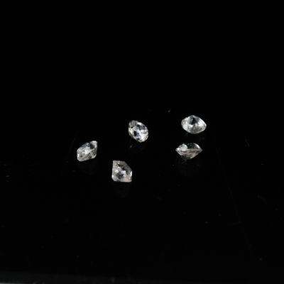 quatre diamants sur une surface noire avec un fond noir