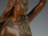 bronze statue of a woman holding a bird in her hand