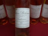 plusieurs bouteilles de vin sont alignées sur une table rouge
