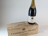 une bouteille de champagne posée sur un coffret en bois