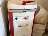 a white and red refrigerator next to a stack of dirty dishes