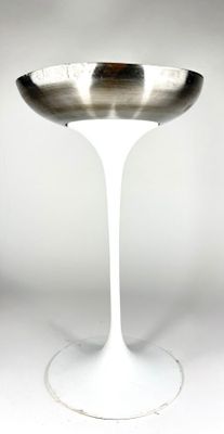 un socle blanc surmonté d'un bol en argent
